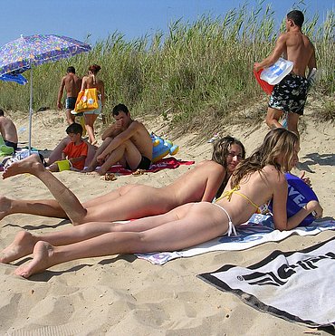 Girl stroking cock on beach
